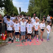 Ein Startbild des 3. Langauer Inklusionslauf 2026 vom 400 Meter Lauf. Darauf sind viele Kinder mit Langauer Laufshirts und ihren Startnummern zu sehen, auf dem Boden steht in roter Schrift 